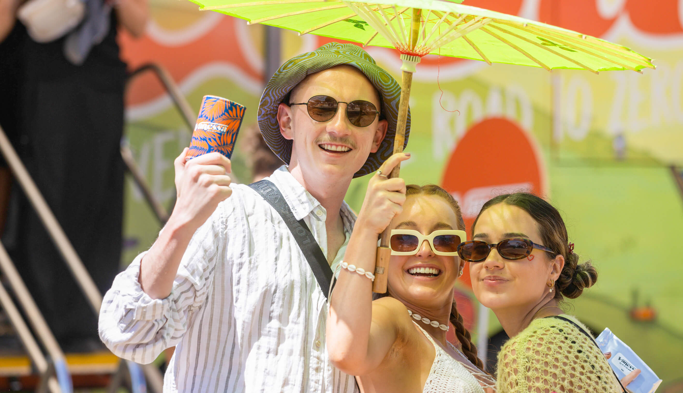 Three young people under sun umbrella